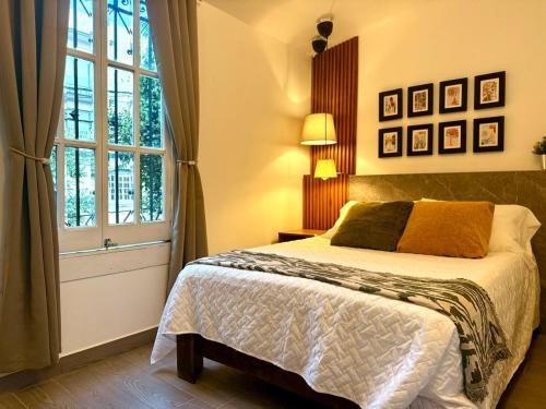 a bedroom with a bed and a large window at Morada Luna Roma in Mexico City