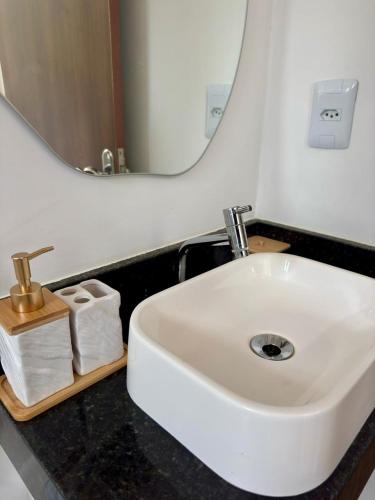 a bathroom with a white sink and a mirror at Villa Davi, A 100m DA PRAIA! in Barra Grande