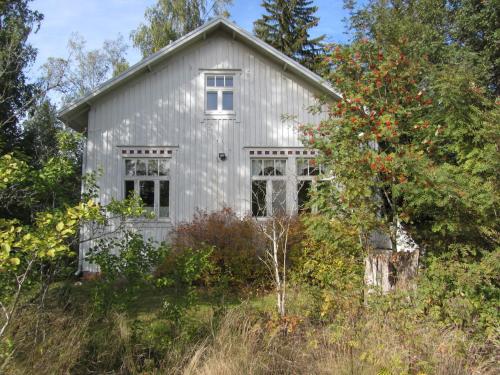 an old white house in the middle of a field at Willa Tapala in Matildedal