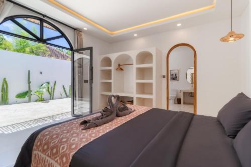 a bedroom with a bed and a large window at Chic 2BR Private Pool Villa in Canggu in Dalung