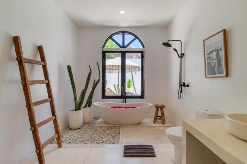 a bathroom with a large tub and a window at Chic 2BR Private Pool Villa in Canggu in Dalung
