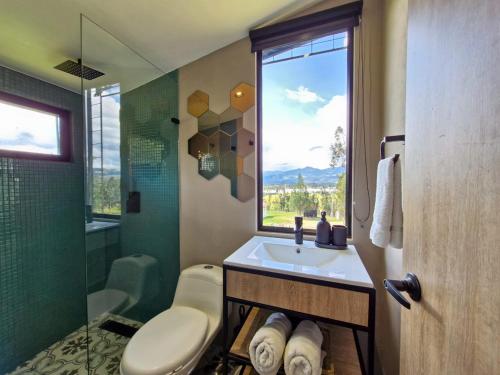 a bathroom with a sink and a shower and a window at Vive Rela Tiny Houses in Nemocón