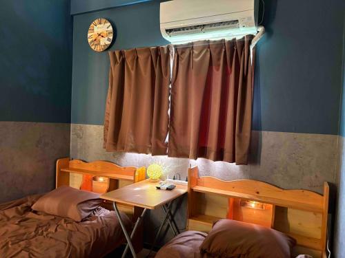 a bedroom with a bed and a table and a window at fishing inn beach house in Amami