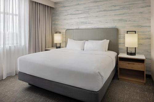 a large bed in a hotel room with two lamps at Embassy Suites Lexington in Lexington
