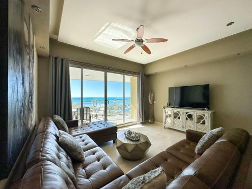 a living room with a couch and a large window at Beachfront Condo with Stunning Views Tranquil Stay in Puerto Peñasco