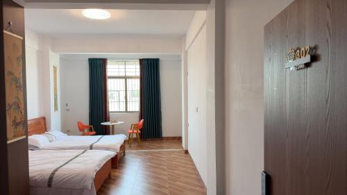 a hotel room with two beds and a window at 道和轩民宿 in Heyuan