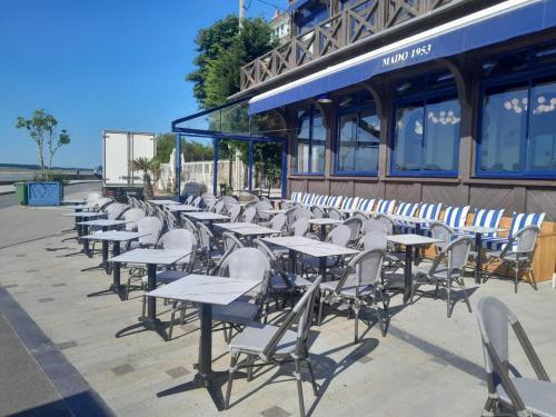 a row of tables and chairs in front of a building at Mado by Scoop in Le Crotoy