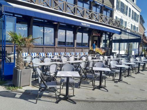 a row of tables and chairs in front of a building at Mado by Scoop in Le Crotoy