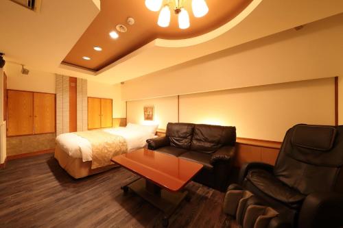 a hotel room with a bed and a couch and chairs at ホテルファインシエル島根松江店 - 大人専用 in Matsue