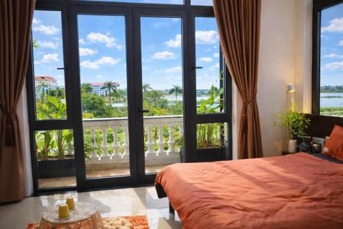 a bedroom with a bed and a large window at Pavillon D'Hue Homestay in Hue