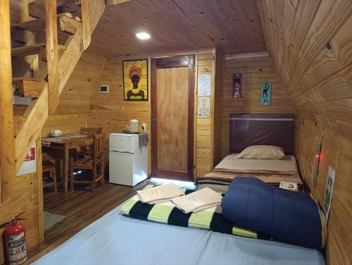 a bedroom with a bed in a wooden cabin at Posada Turística Alpinas Kamba in Paraguarí