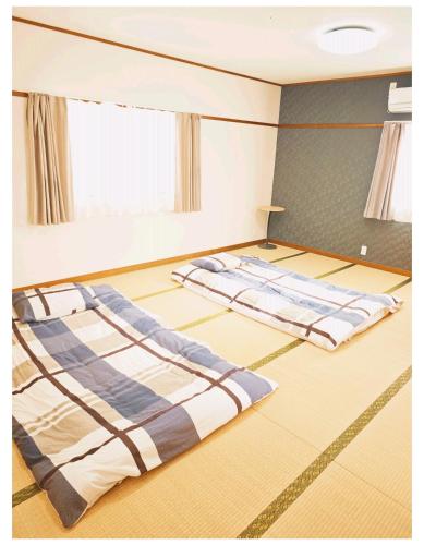 two beds in the middle of a room at 梅田 天王寺へ電車一本 福宿平野 in Osaka