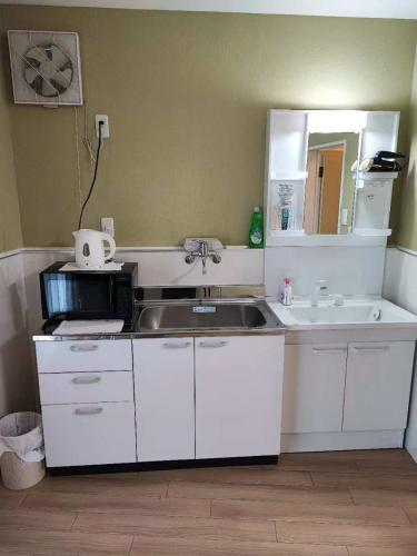 a kitchen with a sink and a microwave at 梅田 天王寺へ電車一本 福宿平野 in Osaka
