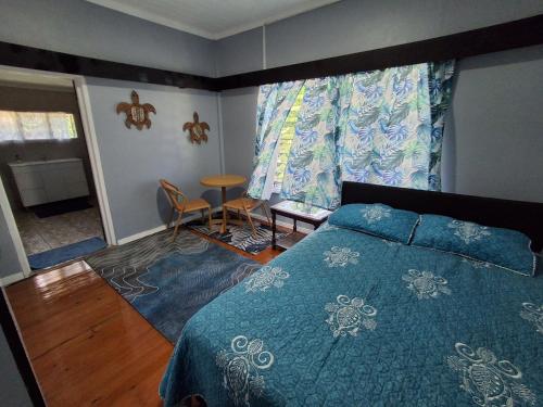 a bedroom with a bed with a blue comforter at Apianas BnB in Suva