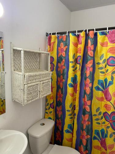 a bathroom with a toilet and a shower curtain at La Casa de Luzma in Pueblo Bello