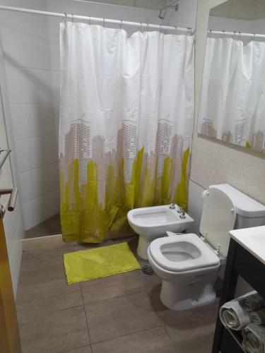 a bathroom with a toilet and a shower curtain at Loft Centro Cívico in San Juan