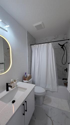 a white bathroom with a toilet and a sink at Private Creekstone Basement Suite with Kitchen in Calgary