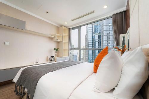 a bedroom with a large white bed with a large window at Elysian Suites In Landmark Saigon by VNS in Ho Chi Minh City