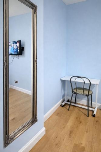 a mirror in a room with a table and a chair at Victoria House - Cozy Rooms in Edmonton