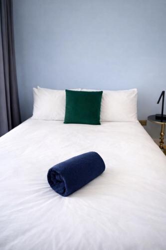 a blue pillow sitting on top of a white bed at Victoria House - Cozy Rooms in Edmonton