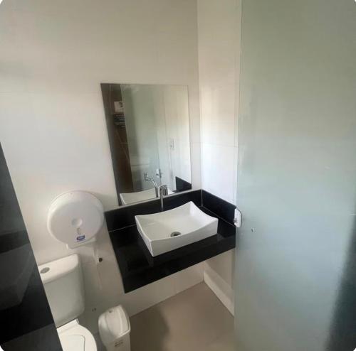 a bathroom with a white toilet and a sink at Ivan Pousada e Churrascaria Bode na Brasa in Feira de Santana