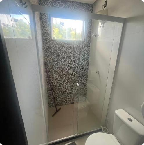 a bathroom with a shower with a toilet and a window at Ivan Pousada e Churrascaria Bode na Brasa in Feira de Santana