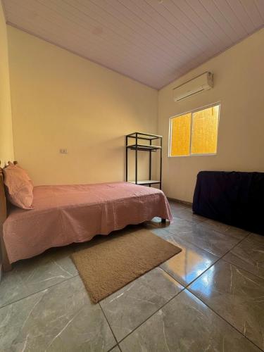 a bedroom with a bed and a window at Casa Grande e Climatizada in Campo Grande