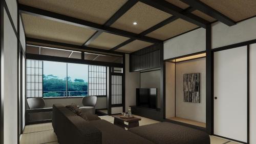a living room with a couch and a television at Gensen Itto Minamiizu in Minamiizu