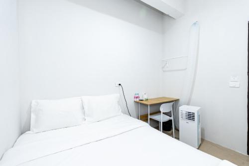 a bedroom with a white bed and a small table at Hims Room Khaosan Road in Bang Bua Thong Railway Station