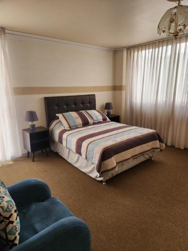 a bedroom with a bed and a couch at MONTELUX Apartamento in La Paz