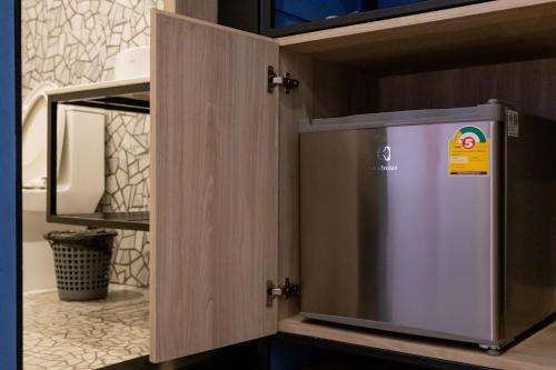 a cupboard with a door open in a bathroom at Penpark Place in Bangkok