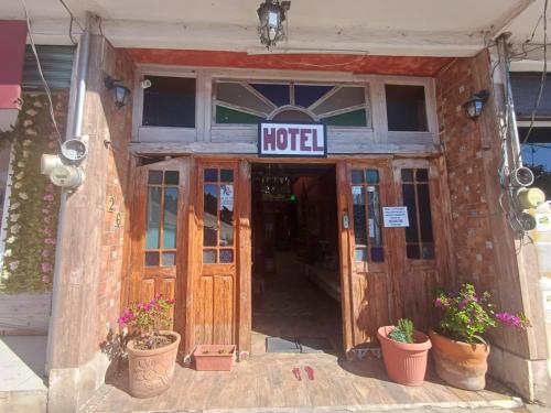 a hotel entrance with potted plants in front of it at Hotel Los Faroles, Villa del Carbón in Villa del Carbón