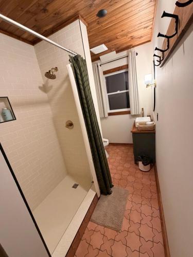 ein Badezimmer mit Dusche und Duschvorhang in der Unterkunft Twin Cities Hotel in Turner Valley