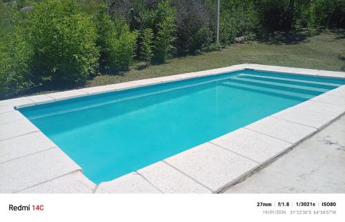 a swimming pool with blue water in a yard at La casa de Anto in Tanti