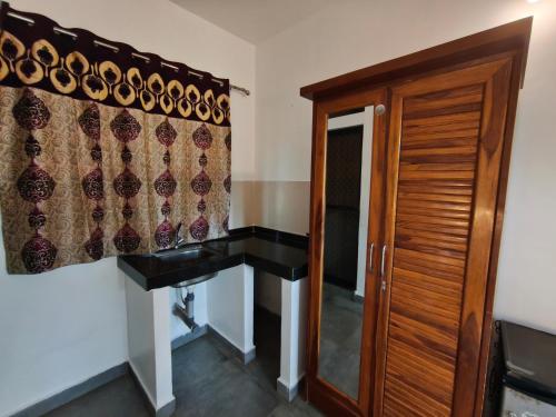 a stairway with a curtain and a wooden door at Sarovar Ashwem in Mandrem
