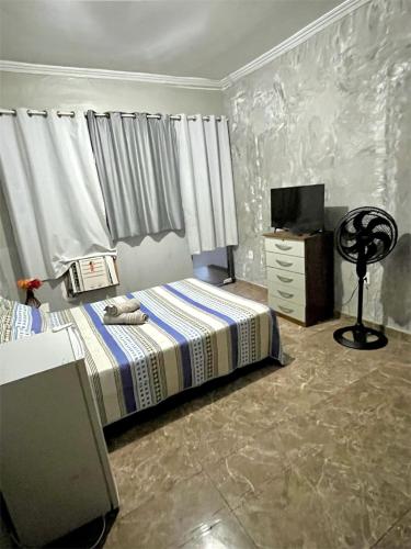 a bedroom with a bed and a dresser in it at Pousada & Espaço Orlla 39 in Maricá
