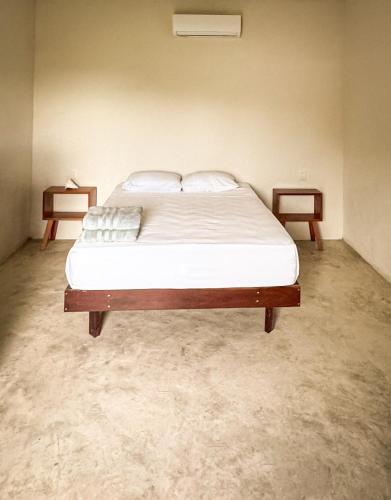 a large bed in a room with two night stands at Apartamento Casa 24 in Bacalar