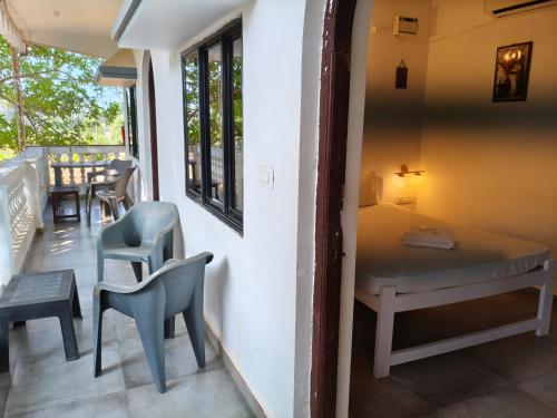a room with a bed and a table and chairs at Sarovar Ashwem in Mandrem