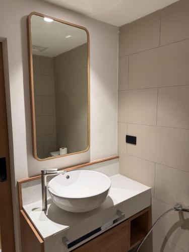 a bathroom with a white sink and a mirror at 611 Hotel in Phetchaburi