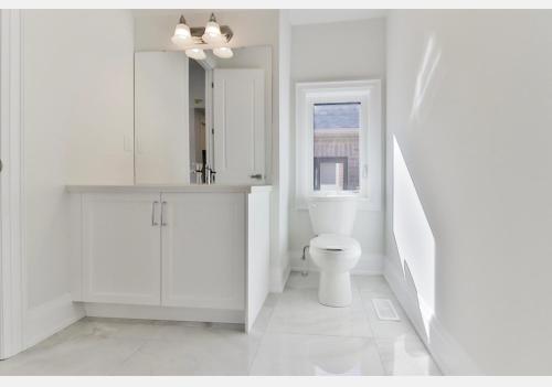 a white bathroom with a toilet and a window at B-Willowdale Cummer Residence -Queen bedroom near Yonge-Finch in Toronto