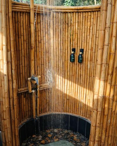a bamboo wall with a shower with water coming out at Omghat Glamping - Domo Sarasvasti in El Peñol