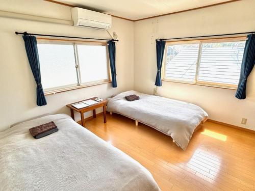 two beds in a room with two windows at SUBAKO - Vacation STAY 90330v in Yurihonjo