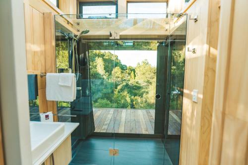 a bathroom with a shower and a glass door at Mākoha PurePod in Kerikeri