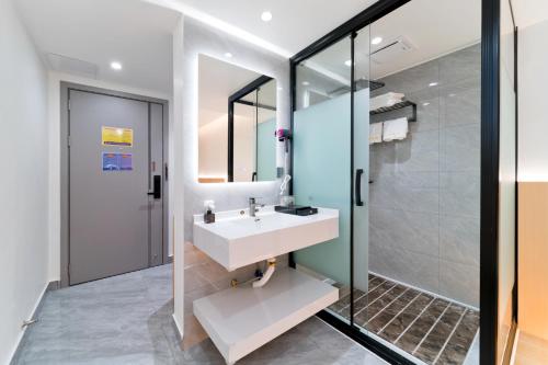 a bathroom with a sink and a shower at Yangshuo YeQi Hotel in Yangshuo