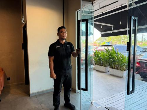 a man standing in front of a glass door at ALL IN HOTEL in Kangar