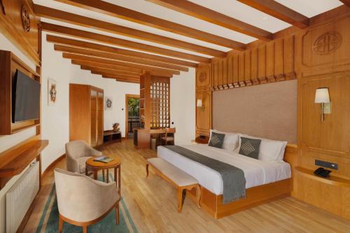 a bedroom with a large bed and a television at Amba Paro in Paro