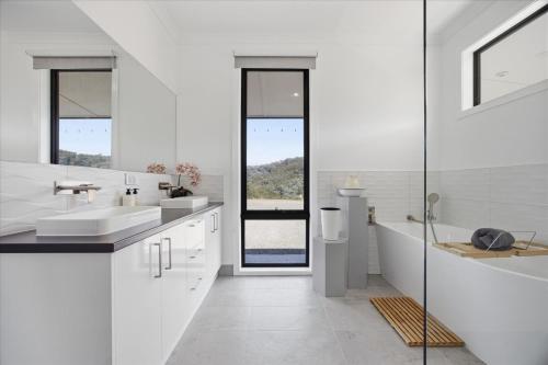 a white bathroom with two sinks and a tub at Eildon Valley Views in Eildon