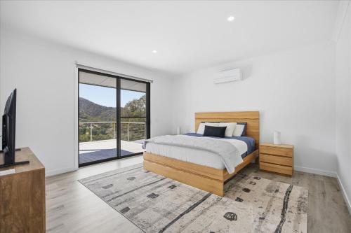a bedroom with a bed and a large window at Eildon Valley Views in Eildon