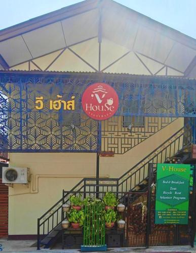 a store with a sign on the side of a building at V House in Phra Nakhon Si Ayutthaya