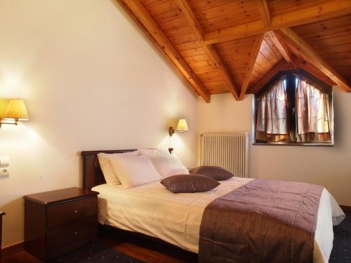 a bedroom with a bed with two pillows on it at Archontiko Tzoumerkon in Agnanta